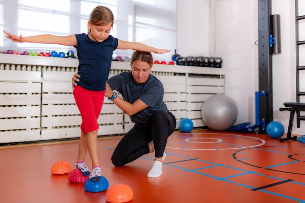 Kindertraining zur Verbesserung des Gleichgewichts und Korrektur von Plattfüßen, Gehen über Stachelhalbbälle
