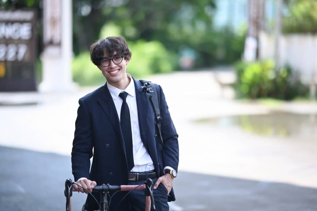 102 Tipps um gesund zu leben: Glücklicher Geschäftsmann, der mit seinem Fahrrad auf der Straße zur Arbeit fährt.