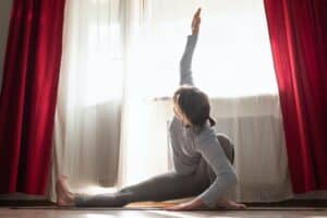 Caucasian woman doing stretching exercise in living room
