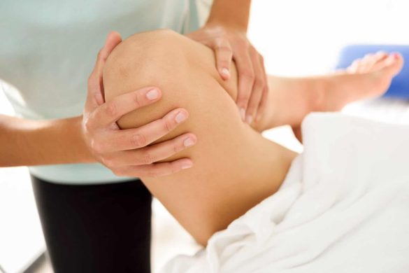 Medizinische Massage am Bein in einem Physiotherapiezentrum. Weibliche Physiotherapeutin bei der untersuchung ihrer Patientin.